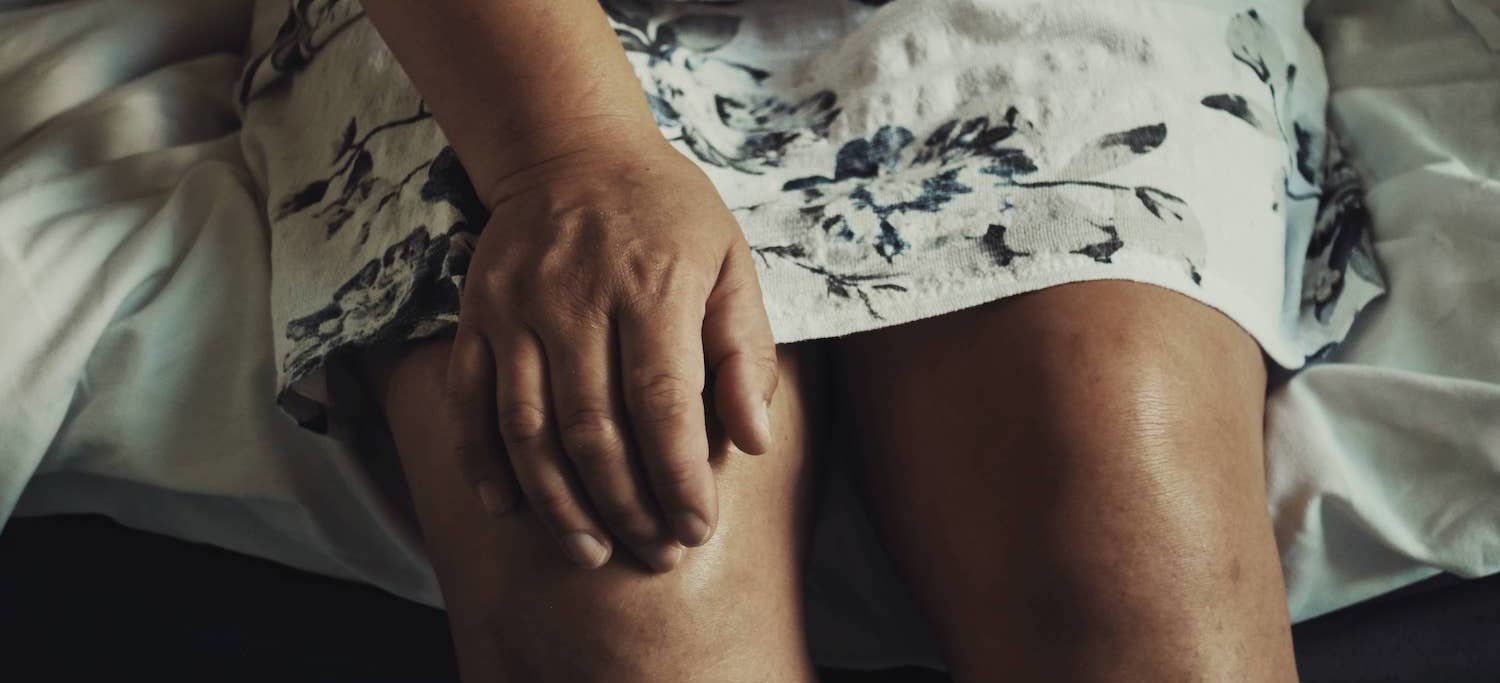 Woman with fibromyalgia massaging her knee