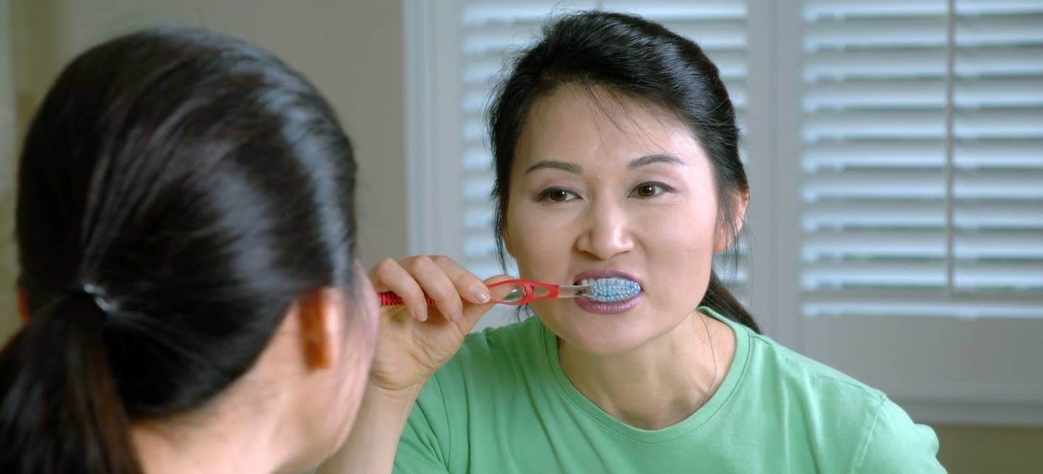 Woman Practicing Oral Healthcare Best Practices at Home - Brushing Her Teeth for Two Minutes Twice a Day